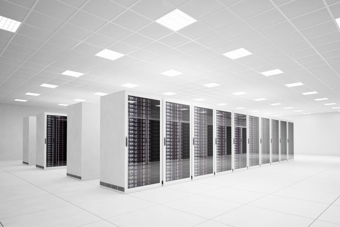 An all-white room with large floor tiles with four rows of white server racks full of electronic equipment.